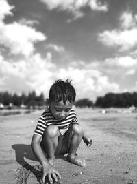 Full length of cute boy on beach against sky