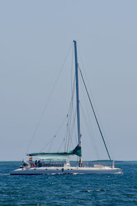 Sailboat sailing on sea against clear sky