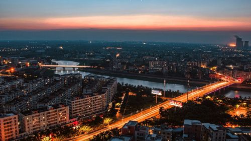 High angle view of illuminated cityscape against sky at night