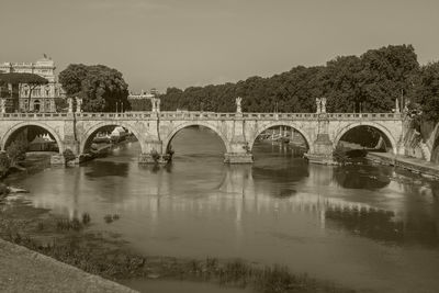 Arch bridge over river against sky