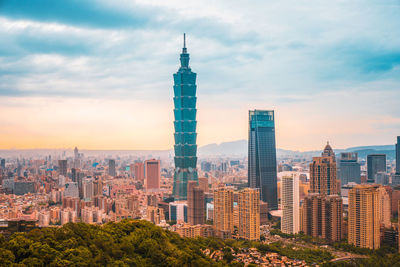 Modern buildings in city against cloudy sky