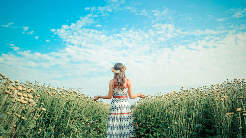 Woman standing on field against sky