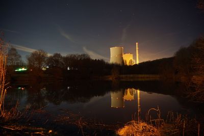 Reflection of buildings in lake against sky at night