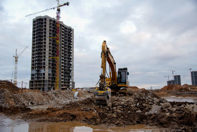 Crane at construction site against sky