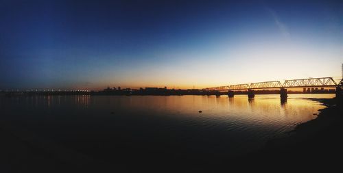 Bridge over river against sky during sunset