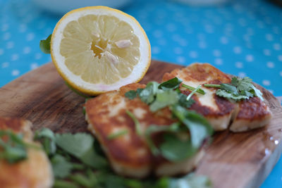 Close-up of halloumi with lemon on cutting board