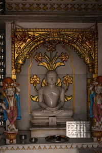 Statue of buddha against wall in building