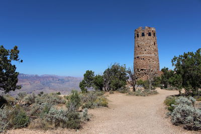 Built structure on landscape against blue sky