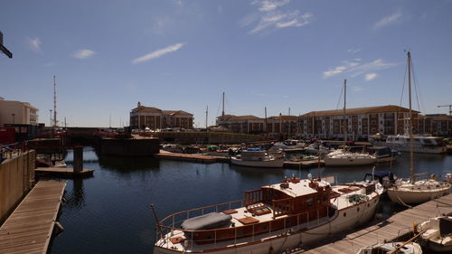 Boats moored at harbor against sky