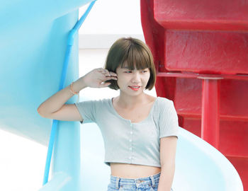 Portrait of smiling girl standing against red wall