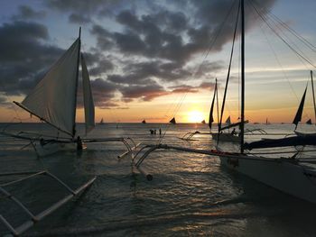 Sailboats on sea against sky during sunset