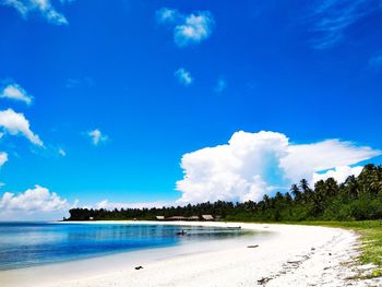 Scenic view of beach against blue sky