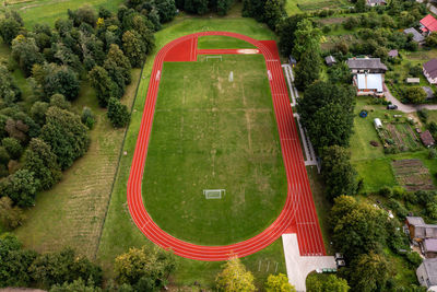 Aerial view of empty green football field and red running tracks, auce, latvia