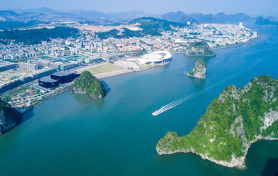 High angle view of cityscape by sea against sky