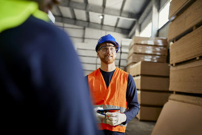 Worker in factory warehouse holding tablet