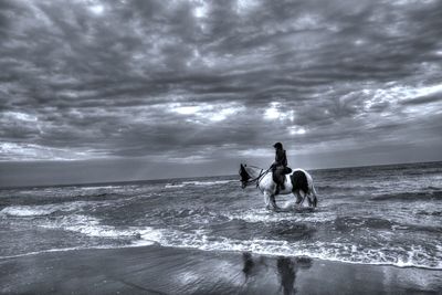 People at beach against sky