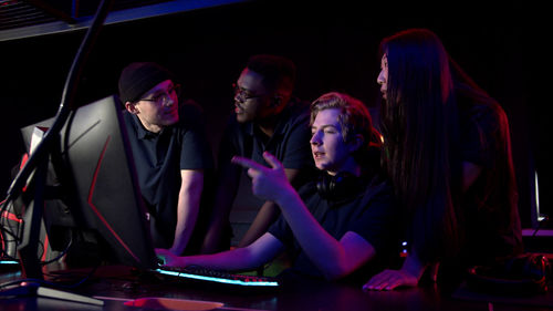 People playing video game in darkroom