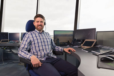 Bearded dispatcher sitting on chair in office