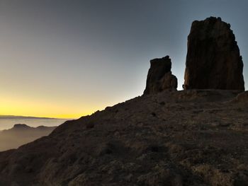 Rock formations on landscape against sky during sunset