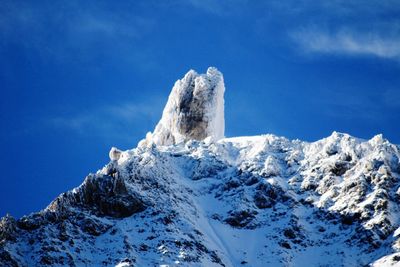 Scenic view of snow mountains against blue sky