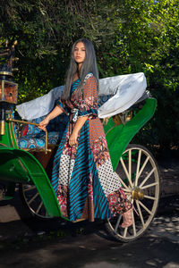 Full length portrait of woman sitting in car