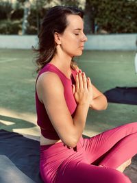 Young woman sitting on pink water