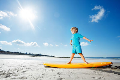 Rear view of man standing on beach against sky