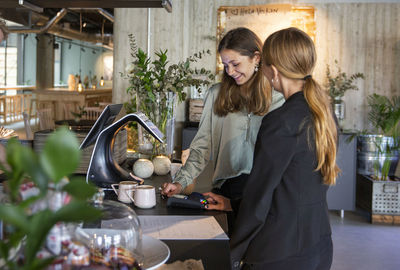 Women paying in cafe