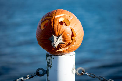 Close-up of pumpkin on wooden post