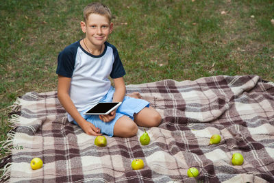 Portrait of smiling boy sitting on grass