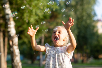 Girl playing with bubbles in park