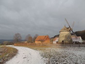 Traditional windmill in winter against sky