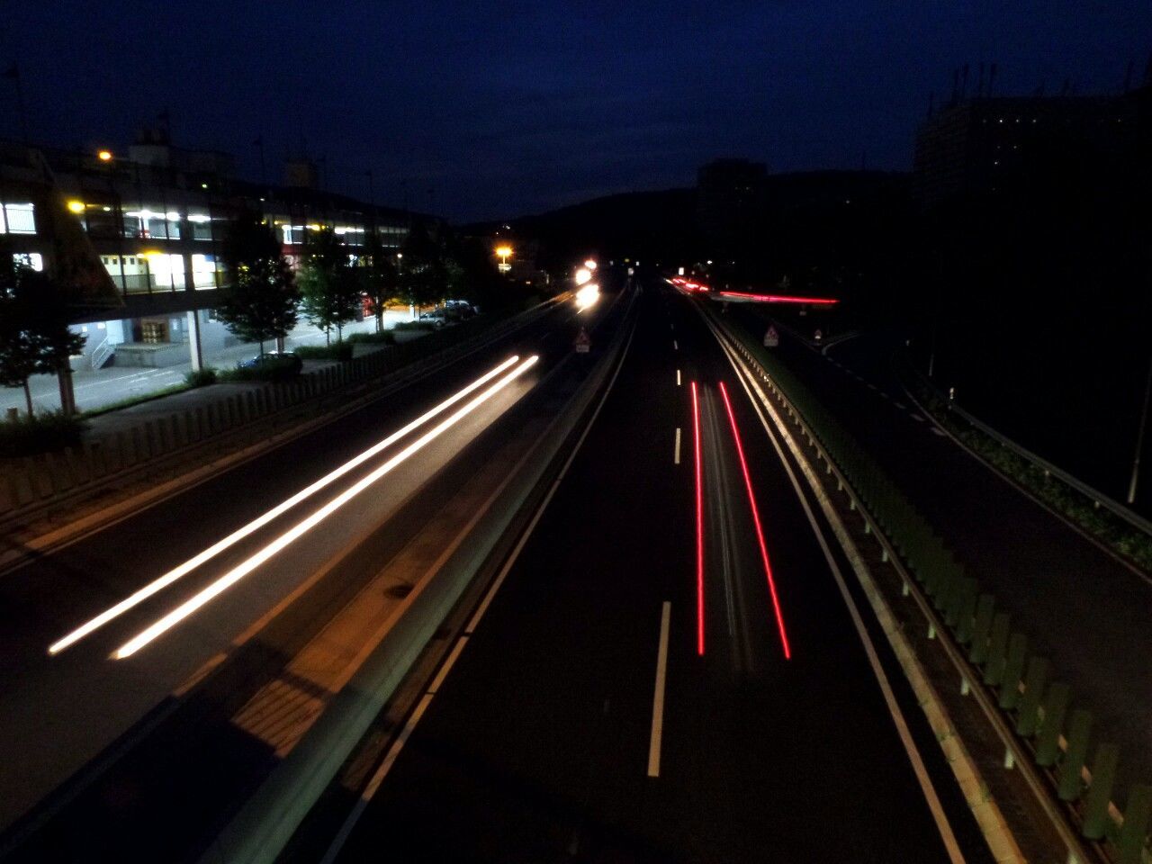 illuminated, night, light trail, transportation, long exposure, speed, high angle view, railroad track, motion, city, road, traffic, building exterior, blurred motion, built structure, street light, the way forward, architecture, highway, sky