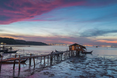 Pier over sea against sky during sunset