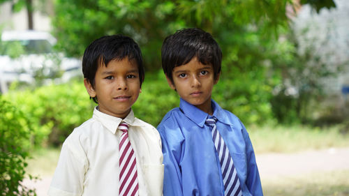 Portrait of young man standing against plants