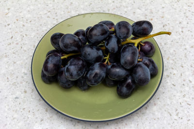 High angle view of grapes in plate on table