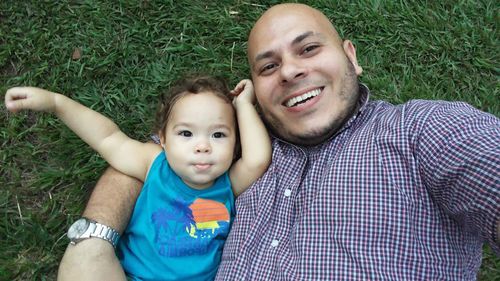 Portrait of smiling father and son lying on grass