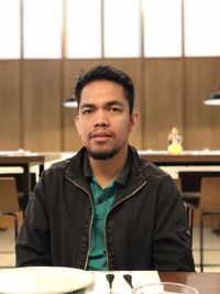 Portrait of young man sitting at table