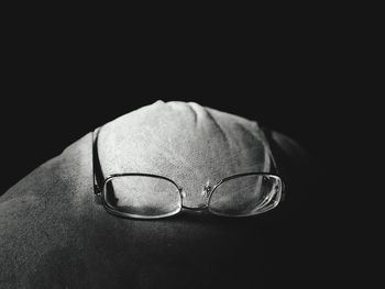 Close-up of eyeglasses on table against black background