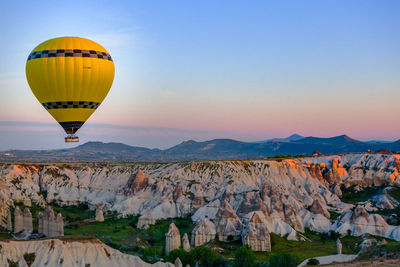 Hot air balloon flying over mountains