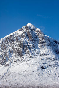 Scenic view of snowcapped mountain against blue sky