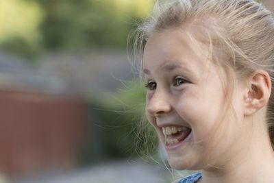 Close-up of cheerful girl looking away