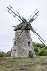 Traditional windmill on field against sky