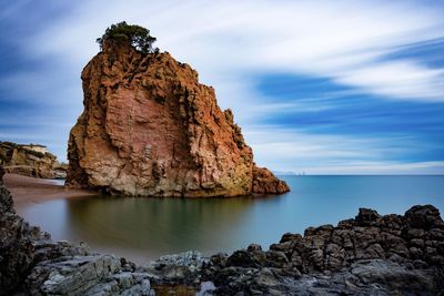 Rock formations by sea against sky