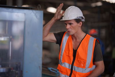 Portrait of young man standing in factory