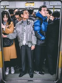 Man and woman using mobile phone while sitting in bus