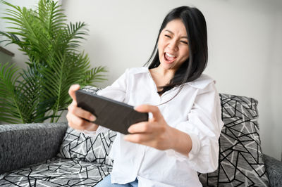 Smiling young woman using mobile phone