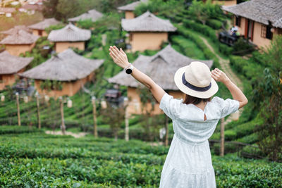 Rear view of woman standing by plants