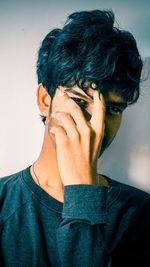 Close-up portrait of young man against wall