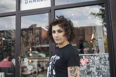 Portrait of man standing by window